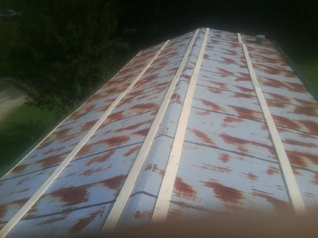 Rusted metal roof panels with new wood purlins before replacement — Storm Damage Roof Repair in Highfalls by Roofing Brothers