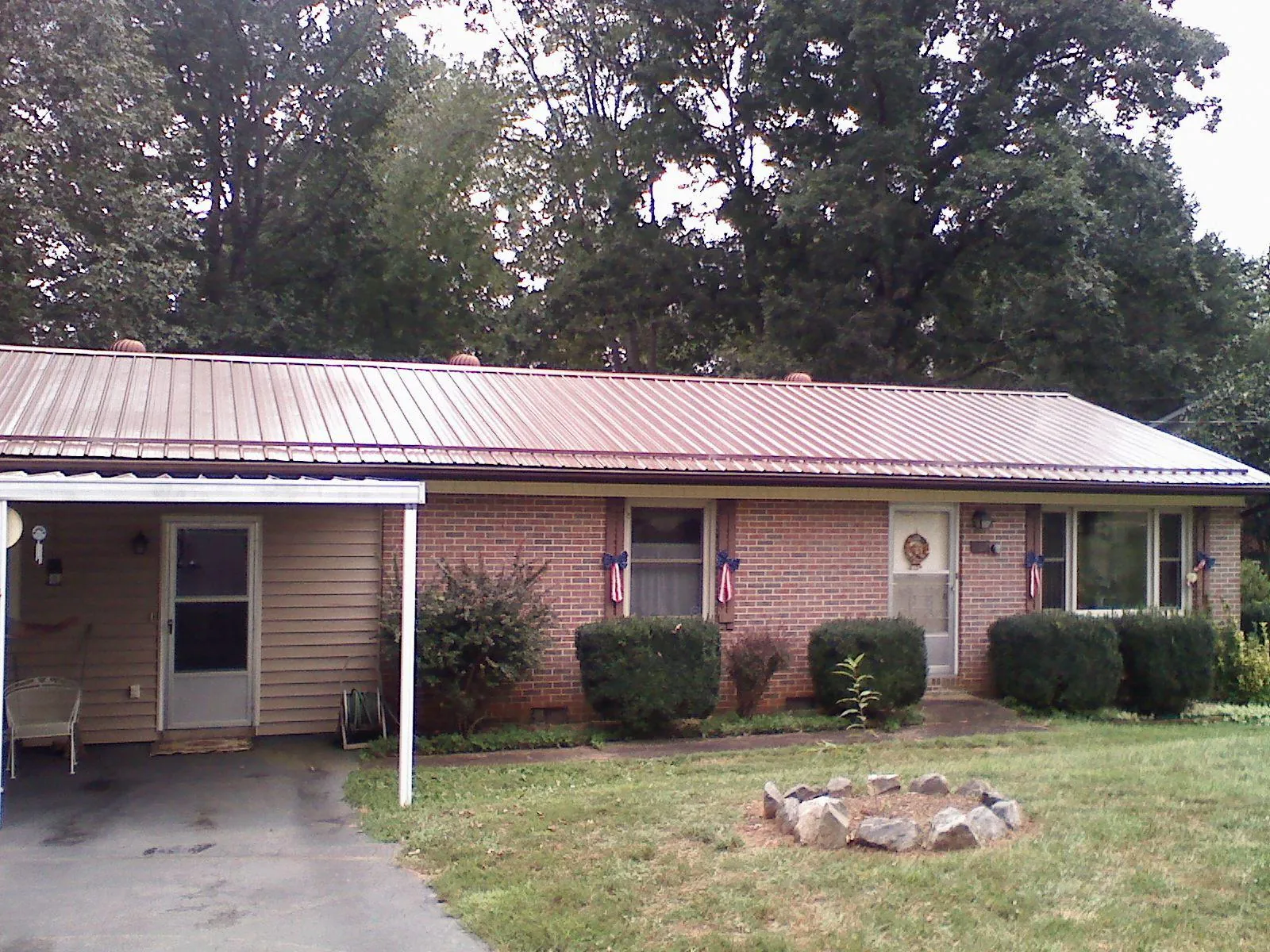 Bronze metal roof and carport on a brick ranch home — Roof Repair work by our crew in Highfalls